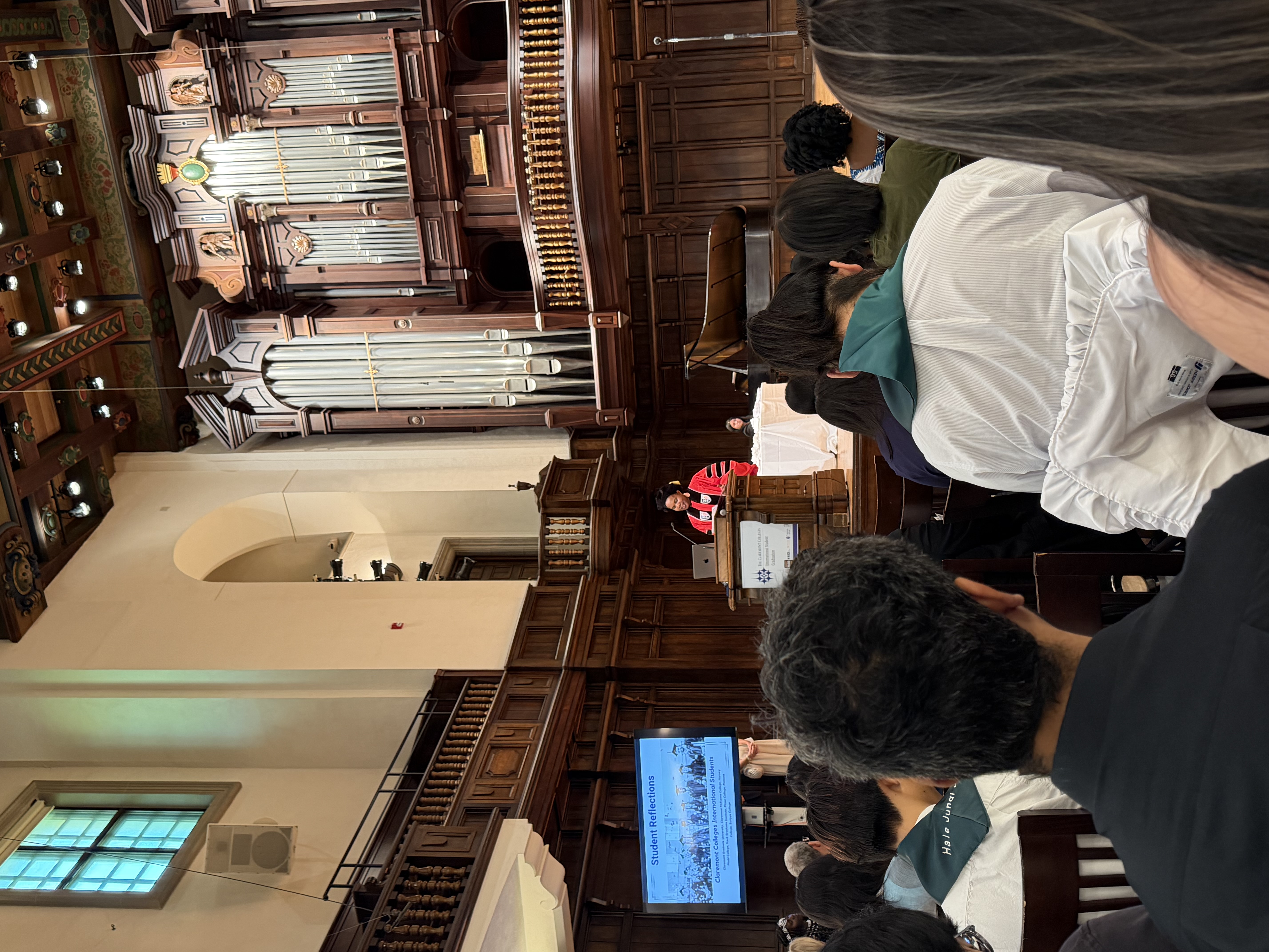 Maria delivering remarks as a student speaker representing Claremont Graduate University at the 7Cs International Student Graduation, 2026.
